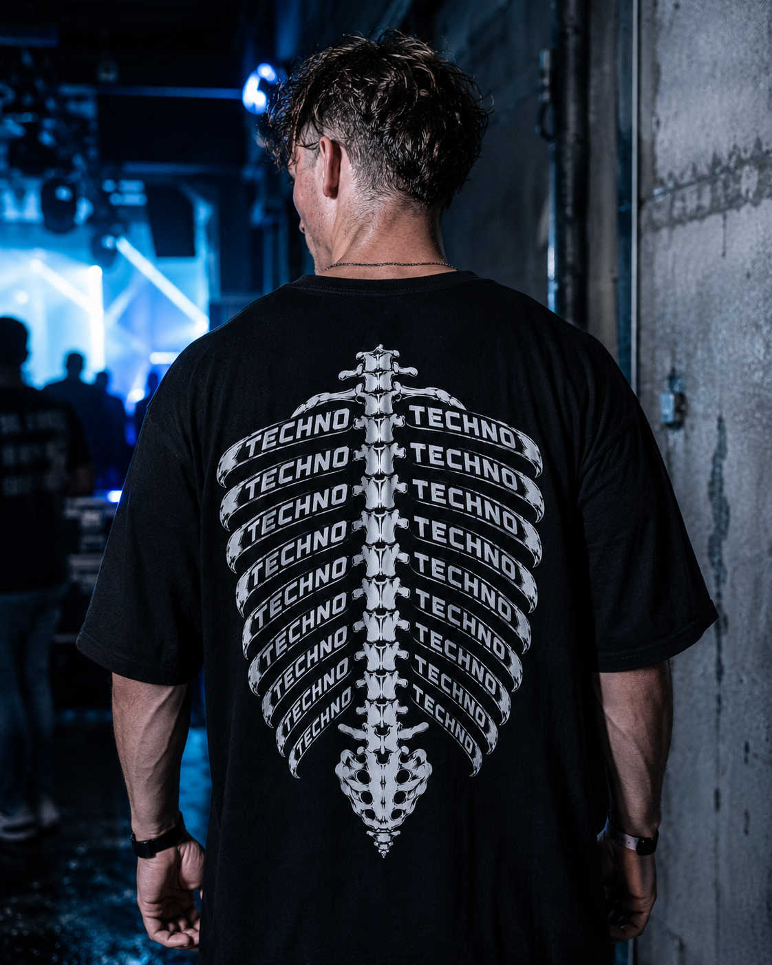 Techno Skelett Oversized Shirt – schwarzes Oversized-Shirt mit Rippen-Rückenprint, getragen im Club