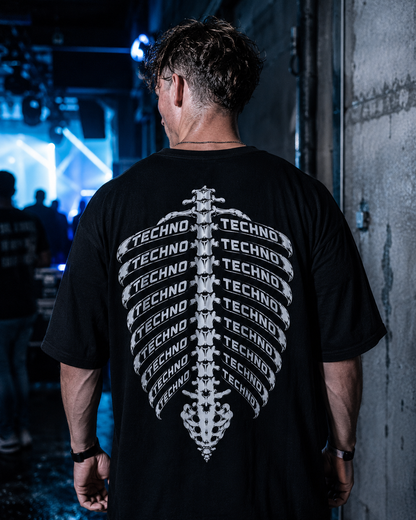 Techno Skelett Oversized Shirt – schwarzes Oversized-Shirt mit Rippen-Rückenprint, getragen im Club